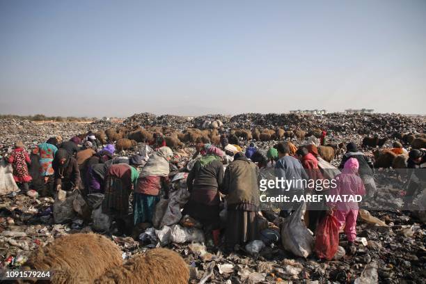 Displaced Syrian displaced women and children sift through trash at a landfill outside a camp in Kafr Lusin near the border with Turkey in Idlib...