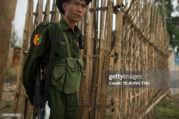 This photo taken on January 12, 2019 shows an armed Pan Say militiaman guarding an area in Muse in Shan state, Myanmar's border town to China. - Ten...