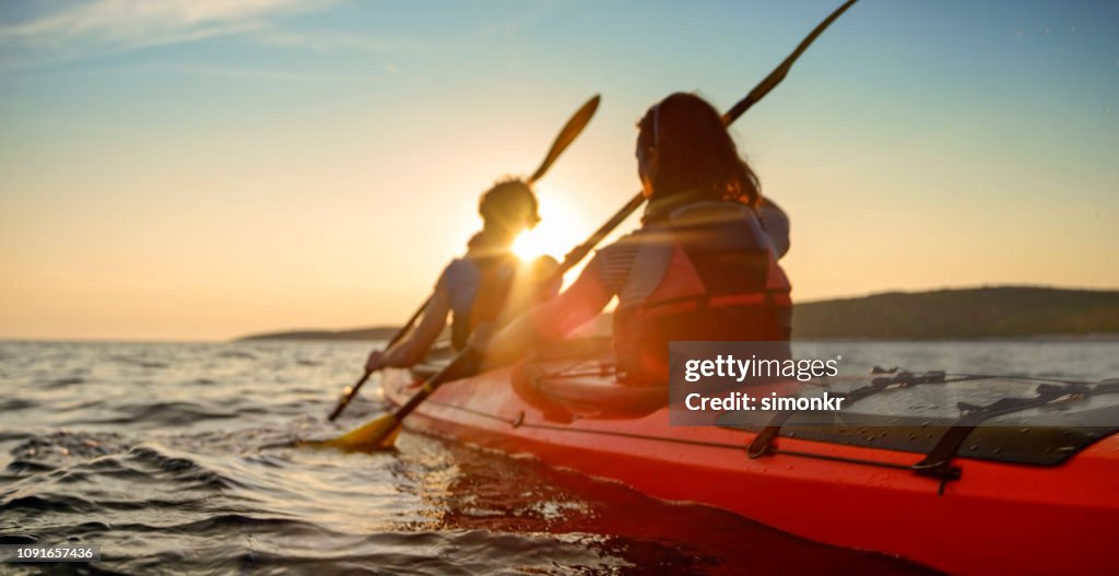 Kayaker rowing in sea