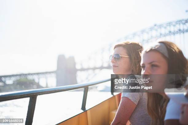 mother and daughters on ferry by sydney harbour bridge - ferry stock pictures, royalty-free photos & images