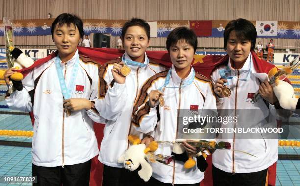China's 4 x 200 freestyle winners Yang Yu , Xu Yanwei , Tang Jingzhi and Zhu Yingwen show their medals during the 14th Asian Games in Busan, 01...