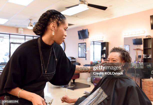 female hairdresser checking clients hair - adjusting hair stock pictures, royalty-free photos & images