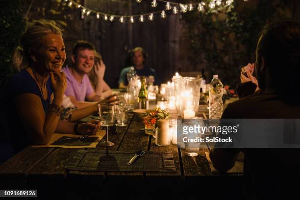 guests talking at a dinner party - dusk stock pictures, royalty-free photos & images