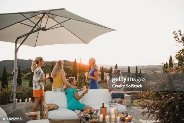 vrouwen die genieten van de zonsondergang op vakantie - luxury europe vacation stockfoto's en -beelden