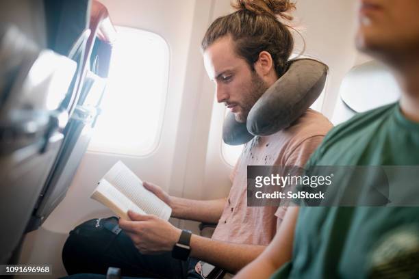 killing time on a flight - travel with book stock pictures, royalty-free photos & images