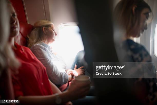 sleeping through the flight - inconvenience stock pictures, royalty-free photos & images