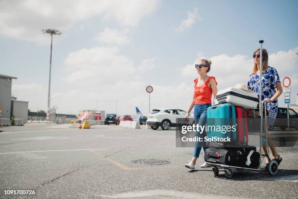 unterwegs zu den mietwagen am flughafen-parkplatz - airport parking stock-fotos und bilder