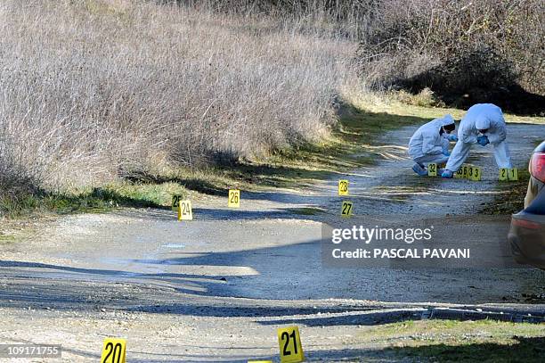 Des experts de la brigade scientifique examinent des traces sur un chemin de la commune de Bouloc, le 15 février 2011, où des effets personnels de...