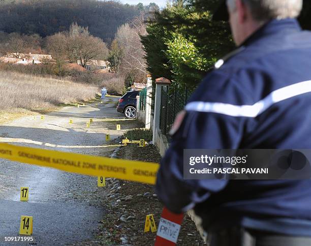 Des gendarmes gardent un périmètre de sécurité alors que des experts de la brigade scientifique examinent des traces sur un chemin de la commune de...