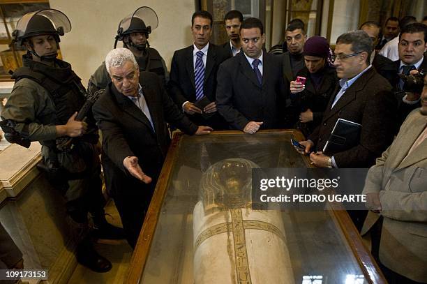 Egyptian state minister of antiquities Zahi Hawass shows one of the pieces damaged by looters and ten repaired at the Egyptian Museum on February 16,...