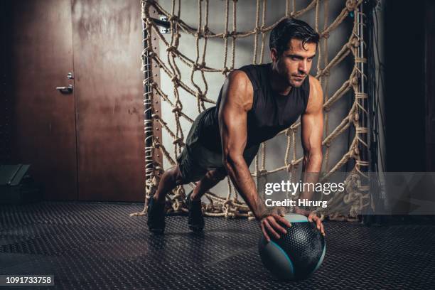 athlete exercises plank pose on medicine ball - medicine ball stock pictures, royalty-free photos & images