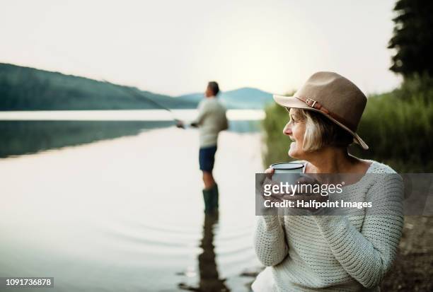 a senior couple fishing on a lake at sunset. - slovakia country stock pictures, royalty-free photos & images