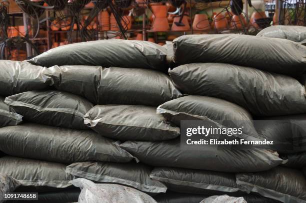 a stack of bags of top soil in a garden center - topsoil stock pictures, royalty-free photos & images