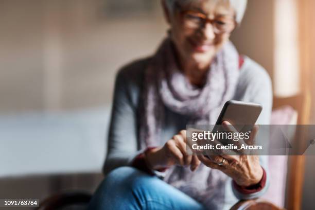 彼女の年長年のスマート テクを滞在 - application mobile ストックフォトと画像