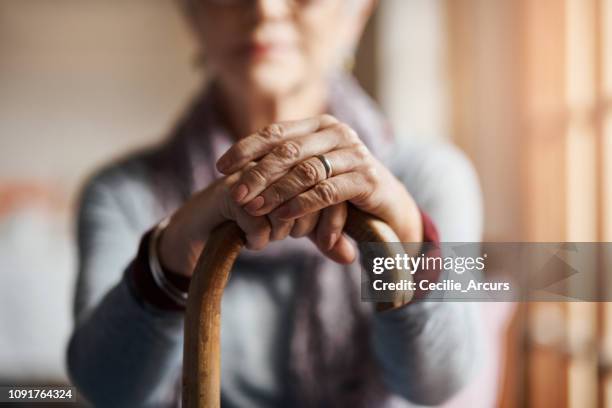 ik krijgen door met een beetje hulp van mijn riet - walking cane stockfoto's en -beelden