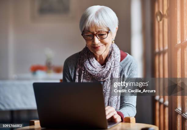 it's never too late to join the online community - middle aged woman at home stock pictures, royalty-free photos & images