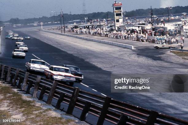 Tiny Lund in a Ford leads the Pontiac of Joe Weatherly and the Chevrolet of Junior Johnson just after the start of the Rebel 300 NASCAR Cup race at...