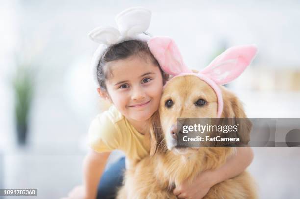 little girl hugging her easter dog - dog easter imagens e fotografias de stock