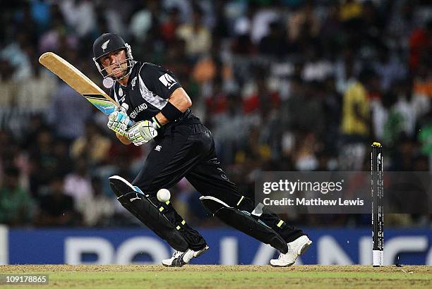 Brendon McCullum of New Zealand pulls the ball towards the boundary, as MS Dhoni of India looks on during the 2011 ICC World Cup Warm up game against...