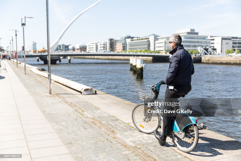 Rear view of man standing with bicycle