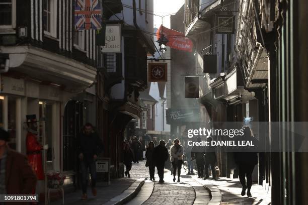 Pedestrians walk along Mercery Lane, one many narrow streets in Canterbury in southern England on January 22, 2019. - In an idyllic stretch of...