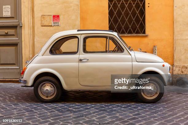 uitzicht op een beige fiat 500 cinquecento geparkeerd op een straat in het centrum van rome ten dage - fiat 500 stockfoto's en -beelden