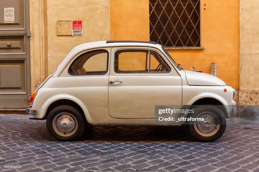 View of a beige Fiat 500 Cinquecento parked on a street in central Rome at day