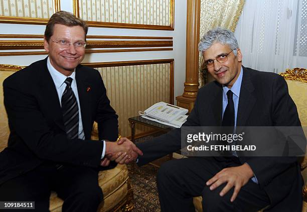 Tunisian Cooperation Minister Mohamed Nouri Jouini shakes hands with German Foreign Minister Guido Westerwelle on February 12, 2011 in Tunis....