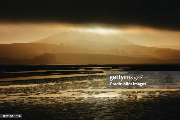 lifting fog at dawn over the sea in a national seashore reserve area. - inverness scotland photos et images de collection