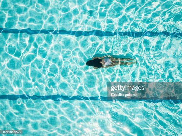 draufsicht auf mädchen idiving im schwimmbad - schwimmen schwimmbad stock-fotos und bilder