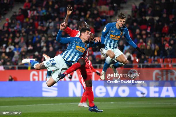 Seydou Doumbia of Girona FC competes for the ball with Jose Gimenez and Santiago Arias of Atletico de Madrid during the Copa del Rey Round of 16...