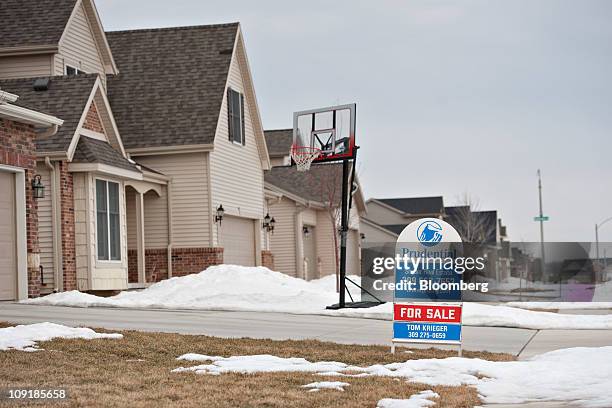 For sale sign stands outside a new home in Bloomington, Illinois, U.S., on Tuesday, Feb. 15, 2011. Builders began work on more homes than forecast in...