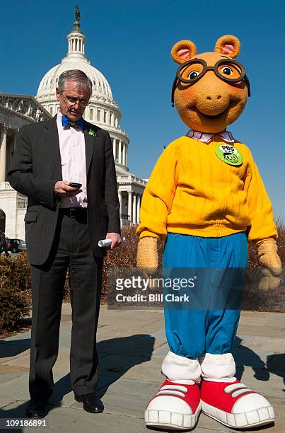 From left, Rep. Earl Blumenauer, D-Ore., checks his phone as Arthur, the aardvark from PBS Kids, looks on during a news conference to announce...