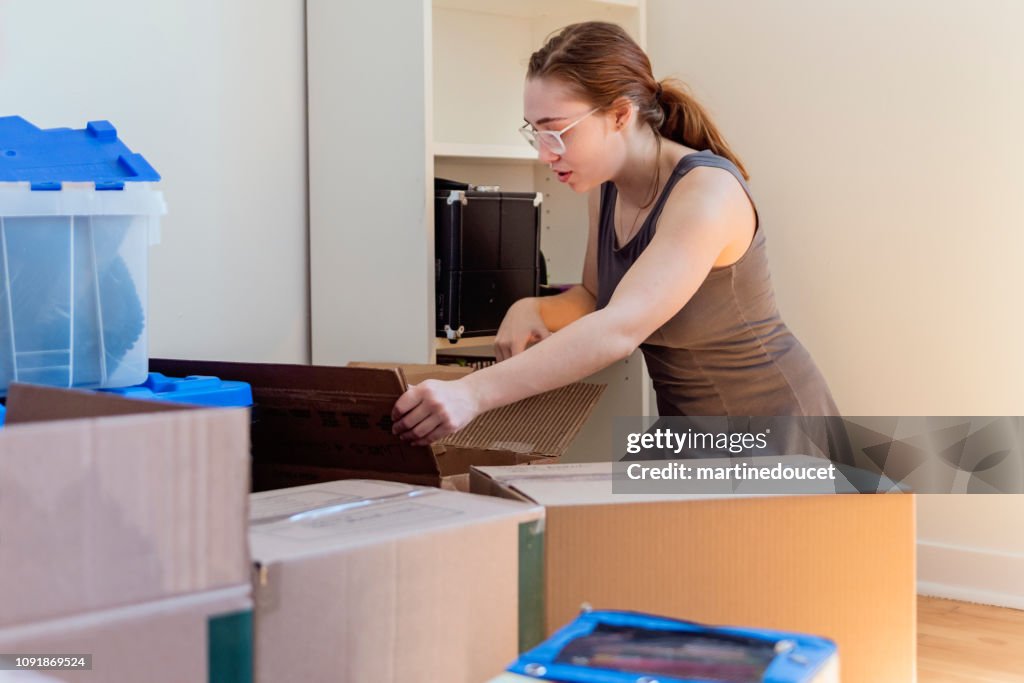 Millennial young woman moving in new apartment.
