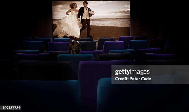 woman sat alone in cinema watching romantic film - kinosaal stock-fotos und bilder