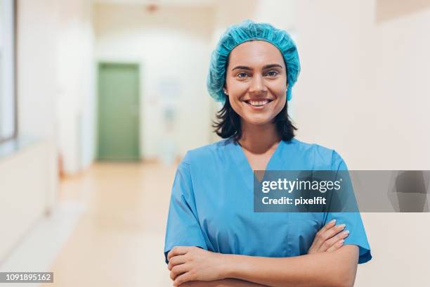 nurse standing in a medical clinic corridor - mid wife stock pictures, royalty-free photos & images