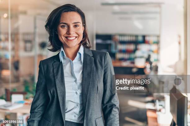 portret van een glimlachende zakenvrouw - zakenvrouw stockfoto's en -beelden