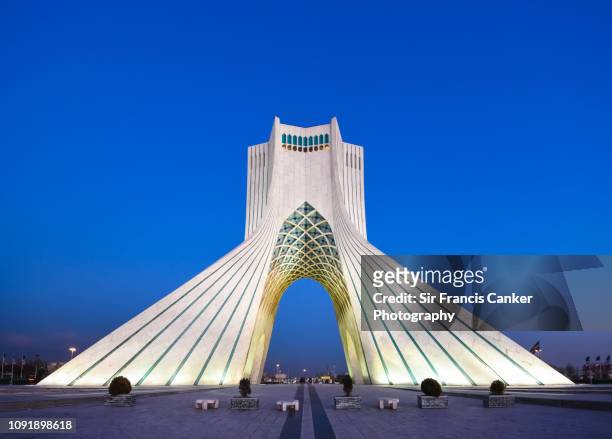 azadi tower illuminated at late dusk in tehran, iran - tehran stock pictures, royalty-free photos & images