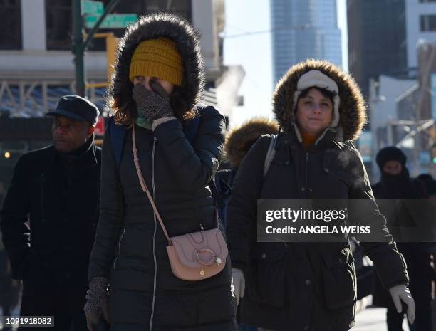 People walk through the freezing cold in the Brooklyn borough of New York on January 31, 2019. - A brutal cold wave moved eastward Thursday after...