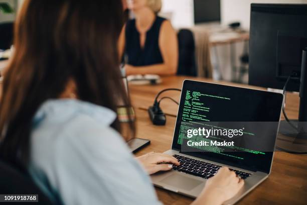 female computer programmer working at desk in creative office - mobile developer stock pictures, royalty-free photos & images