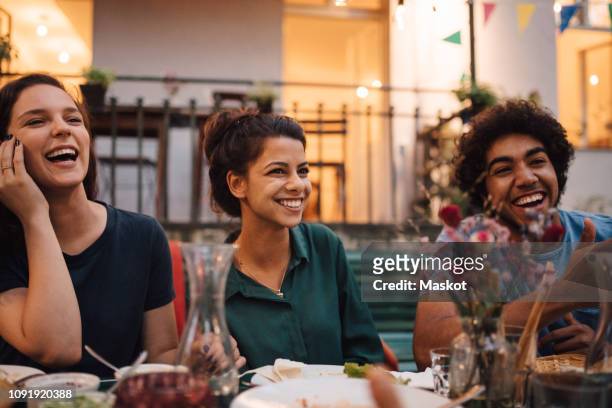 happy young friends enjoying dinner party in backyard - evening meal restaurant stock pictures, royalty-free photos & images