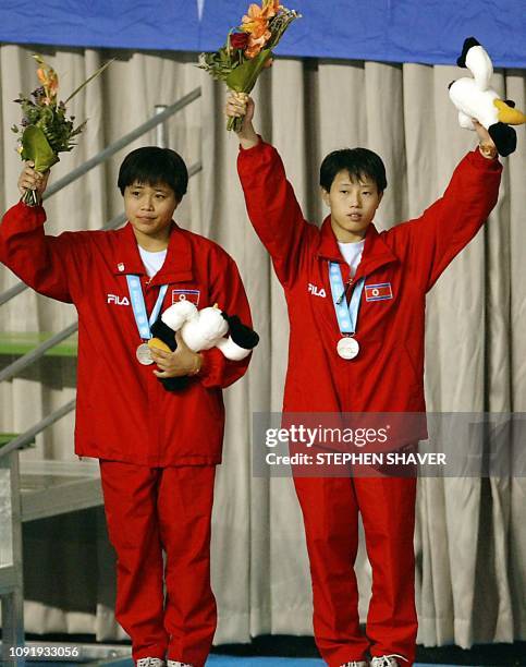 North Korea's Jon Hyon-Ju and Kim Kyong-Ju celebrate after winning the silver medal in the women's synchronized diving finals 09 October 2002 during...