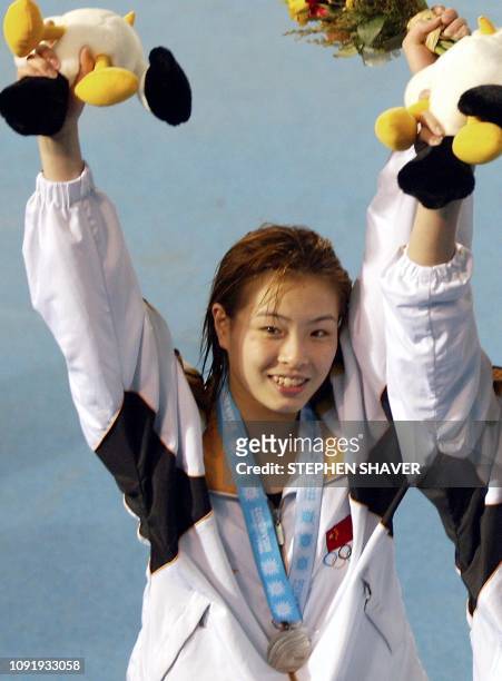 China's Wu Minxia celebrates winning the silver medal during an awards ceremony for the women's 3-metre springboard final, 10 October 2002 at the...