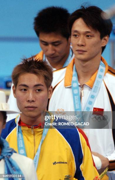 China's Wang Tian Ling poses on the podium with bronze medallist from Malaysia, Yeoh Ken Nee and silver medallist Wang Feng of China after receiving...