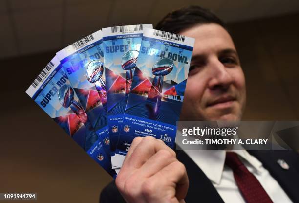 Michael Buchwald, NFL Senior Counsel, Legal, holds counterfeit game tickets during a press conference at the Super Bowl Media Center in Atlanta,...