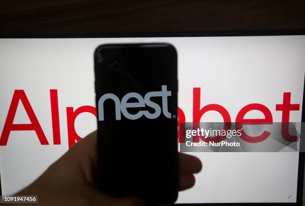 The logo of Nest is seen on a screen. In the background there is the logo of Alphabet. Alphabet is the mother company of Google. It has a revenue of...