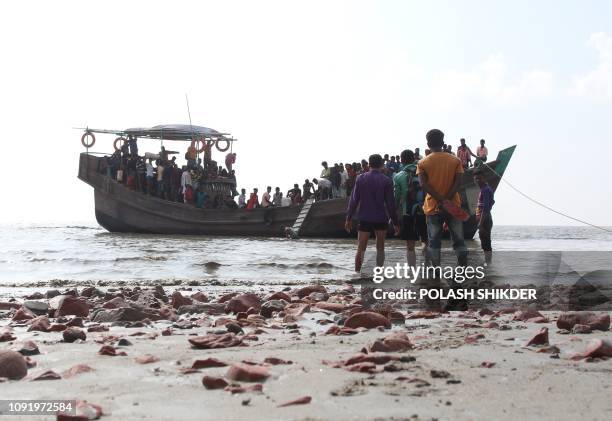 In this photograph taken on October 15 show people getting off a boat in Bhashan Char island off the Bangladeshi coast, as it was being prepared for...