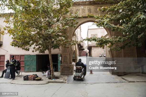 Police officers stand guard on a street as a motorist drives past in Kashgar, Xinjiang autonomous region, China, on Thursday, Nov. 8, 2018. Although...