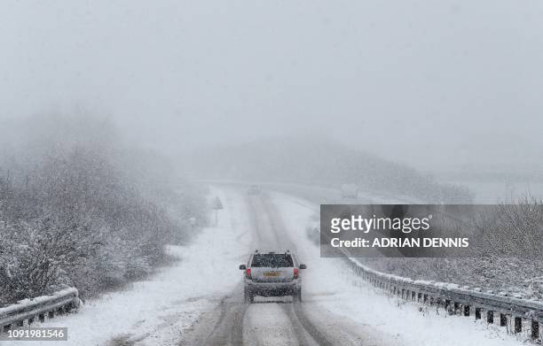 Car is driven along a slip road leading to the snow and sleet-covered A34 road a near Chievely, in Berkshire, west of London, on February 1, 2019. -...