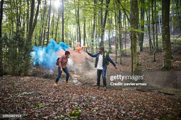 happy couple with distress flares in woodland - distress flare stock pictures, royalty-free photos & images